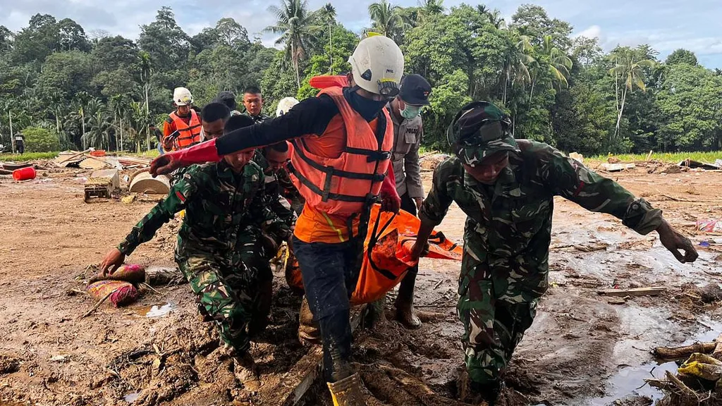 Rescuers in Indonesia search for hundreds buried under landslides