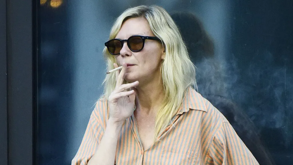 Kirsten Dunst puffs on a cigarette outside a cafe in Los Angeles