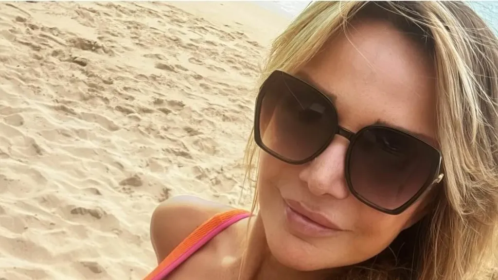 Lizzie Cundy poses up a storm in an orange swimsuit in Barbados