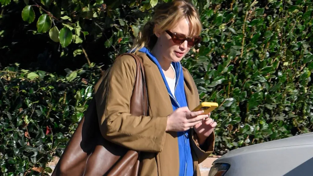 Jennifer Lawrence's baby bump peeks out from her raincoat